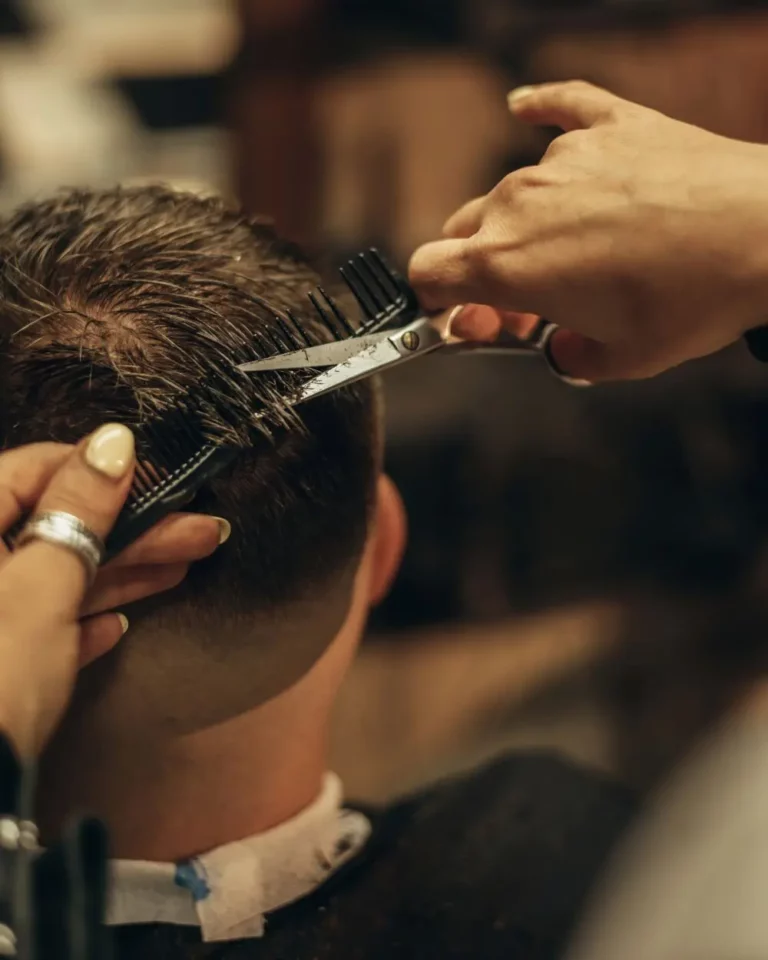 Man Getting a Haircut by Woman Stylist